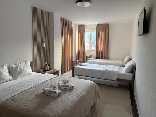 a hotel room with two beds and a television at Hotel Majestic in Struga