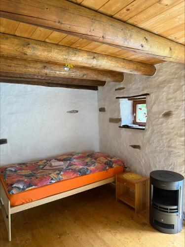 a small bedroom with a bed in a cabin at Rustico Indéman in Gambarogno
