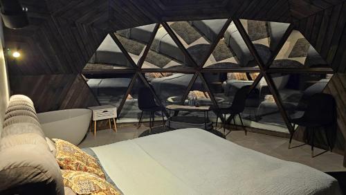 a room with a bed and a tub in a tent at Trys su puse upės in Dzidai