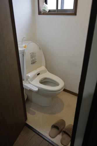 ein Badezimmer mit einer Toilette, deren Deckel offen ist in der Unterkunft 民宿プラトーハウス in Namerikawa