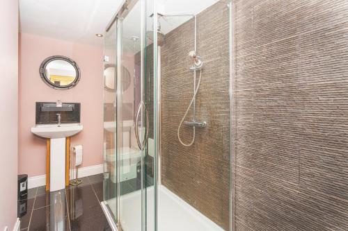 a bathroom with a glass shower with a sink at Navitie Apartment in Ballingry