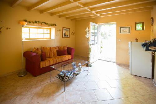 un salon avec un canapé et une table en verre dans l'établissement Chambres d'hôtes La Ferme du Grand Launay, à Semblançay