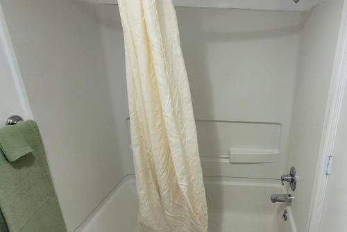 a white shower curtain in a white bathroom at Coratel Inn and Suites By Jasper Anthony in Anthony