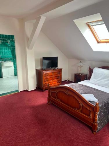 a bedroom with a bed with a television and a dresser at Mini hotel Na konci in Krupka