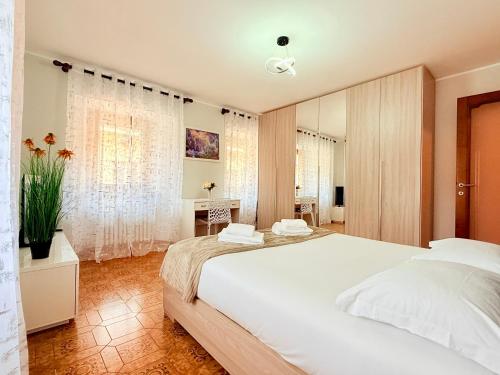 a bedroom with a large white bed and a desk at Casa di Mary in Châtillon