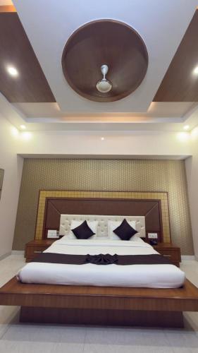 a bedroom with a large bed with a ceiling at Hotel Panigrahan in Bikaner