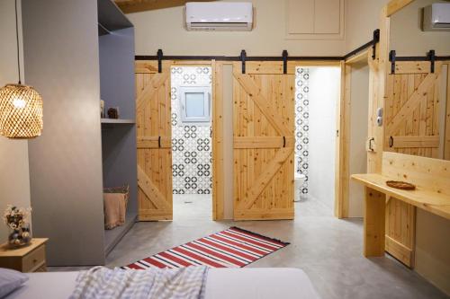 a room with wooden doors and a rug at The Beach House at Oz Bay in Pantoukiós