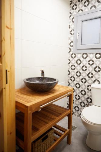a bathroom with a bowl sink on a wooden counter at The Beach House at Oz Bay in Pantoukiós