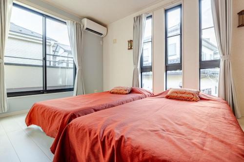 two beds in a room with large windows at Sea Breeze 三浦 in Miura