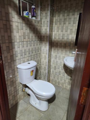 a bathroom with a toilet and a sink at PiemStays in Ruaka