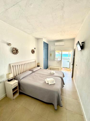 a bedroom with a bed with a towel on it at Hostal Rios in Bolonia