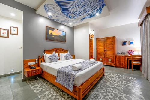 a bedroom with a large bed and a desk at Resort Terra Paraiso Goa - A Beach Property in Calangute
