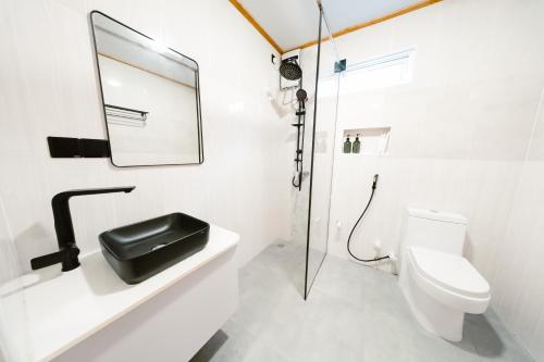 a bathroom with a toilet and a mirror on a sink at Oasis Retreat Dhiffushi in Dhiffushi