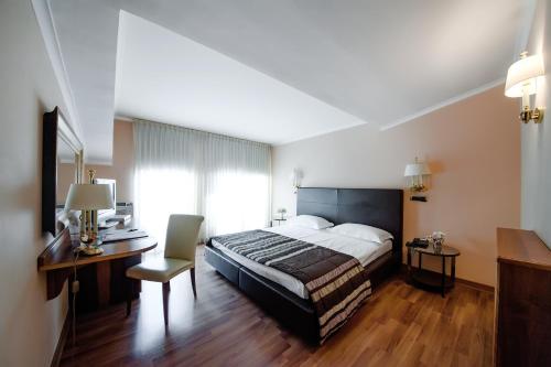 a bedroom with a bed and a desk and a chair at Hotel Villa Traiano in Benevento