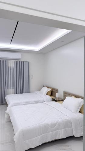 two white beds in a white room with a ceiling at Villa Al Khair in Medina