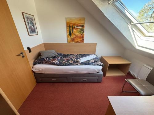 a small bedroom with a bed in the attic at Hotel Friesenhof in Westoverledingen