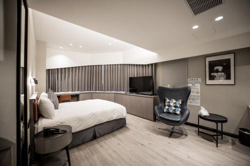 a hotel room with a bed and a chair at 南兜漫旅 in Tainan