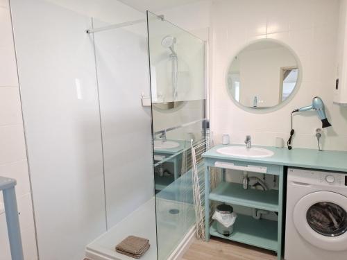 a bathroom with a shower and a sink and a washing machine at L'ESPOIRENTHESE T2 35m2 in Nieuil-lʼEspoir