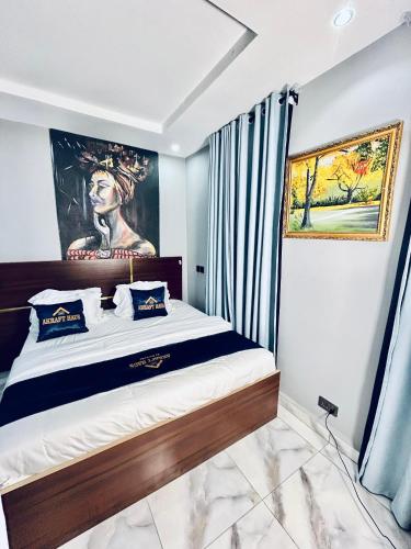 a bedroom with a bed with a painting on the wall at Akrafthaus by KAVKANZ in Abuja