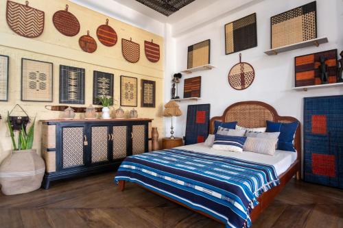 a bedroom with a bed and some pictures on the wall at Heirloom Guesthouse in Dimāpur
