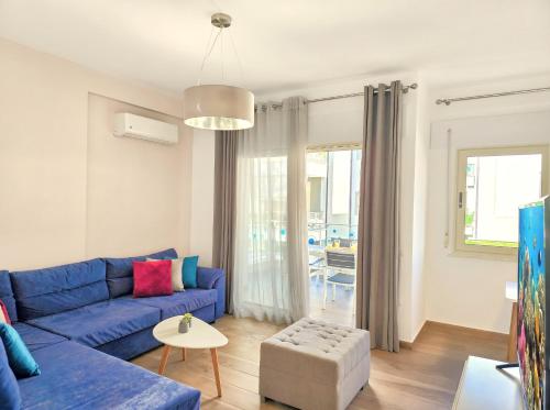 a living room with a blue couch and a table at Sunny Beach Apartments - 147 in Durrës