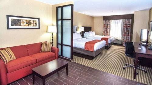a hotel room with a couch and a bed at Holiday Inn Express & Suites Elkton - University Area by IHG in Elkton