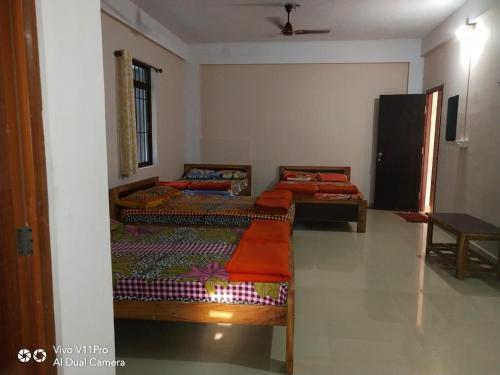 a room with three beds in a room at Amrutha Easy Stay in Kalasa