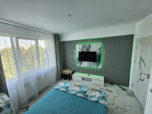 a bedroom with a bed and a flat screen tv at Sejur la mare in Mangalia