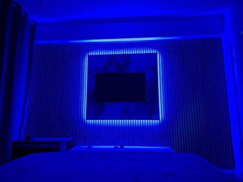 a blue room with a bed and a television at Sejur la mare in Mangalia