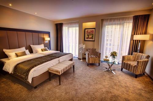 فندق فافور في دوسلدورف: غرفة نوم بسرير كبير وكرسيين