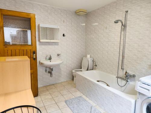 a bathroom with a tub and a toilet and a sink at Altstadthaus Marille mit Innenhofterrasse in Melk