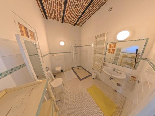 a bathroom with a sink and a toilet and a mirror at La Ferme de la Sensée in Gouy-sous-Bellonne
