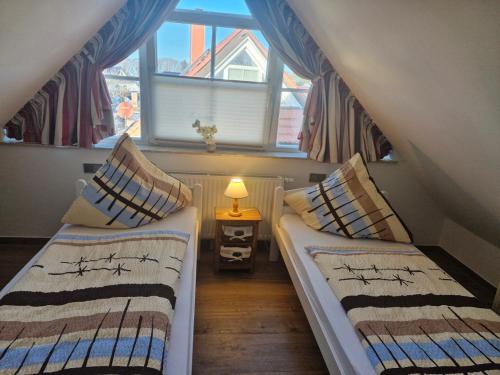 two beds in a room with a window at STRANDROSE - 300m zum Strand - Kamin - Sauna in Zingst
