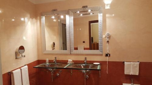 a bathroom with two sinks and a large mirror at Hotel Villa Traiano in Benevento