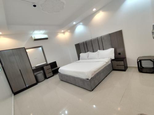 a bedroom with a large bed and a mirror at شالية الكناري in Taif