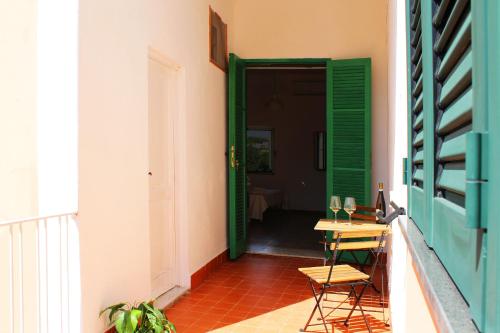 a room with a table and a green door at Il Melograno in Ischia