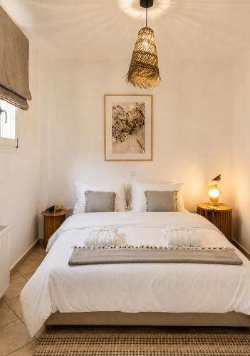 ein Schlafzimmer mit einem großen weißen Bett in einem Zimmer in der Unterkunft YouGa Nest in Vívlos