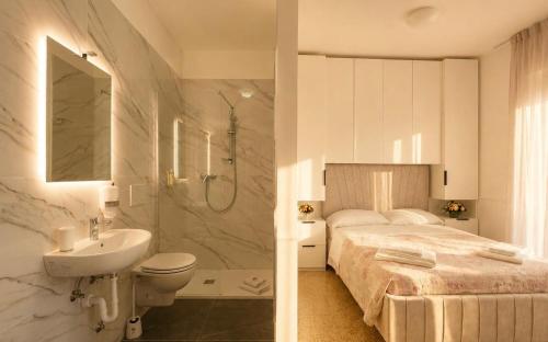 a bathroom with a bed and a sink and a toilet at Villa Emma in Nago-Torbole
