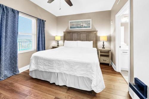 a bedroom with a white bed and a window at Laketown Wharf 903 in Panama City Beach