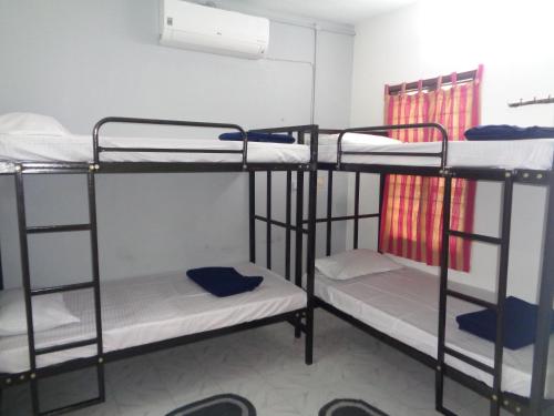a room with three bunk beds in a dorm at Urban Hostels in Tiruvannāmalai