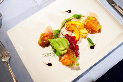 a white plate with food on a table at Parkhotel Tristachersee in Lienz