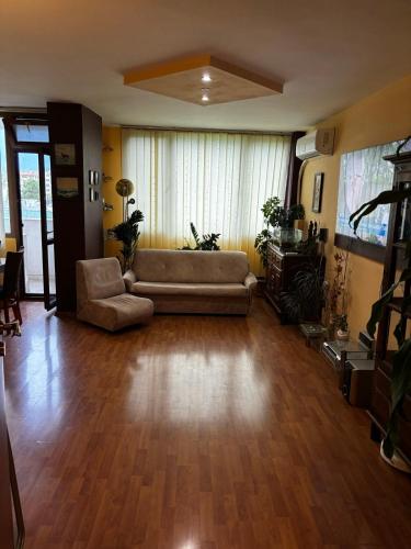 a living room with a couch and a table at Голям двустаен апартамент in Burgas