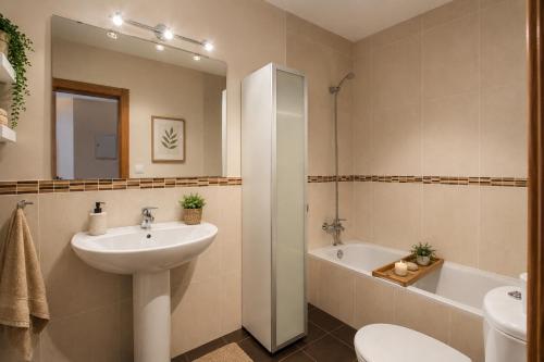 a bathroom with a sink and a toilet and a tub at Apartamento La Castañera in Colombres