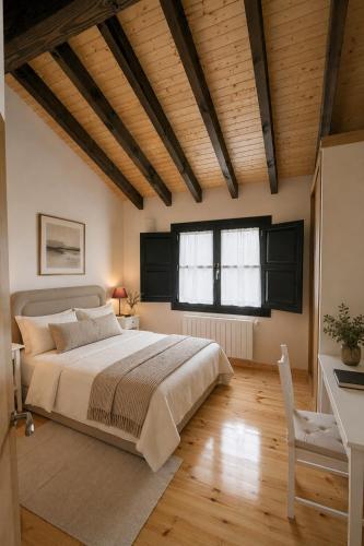a bedroom with a large bed and a wooden ceiling at Apartamento La Castañera in Colombres
