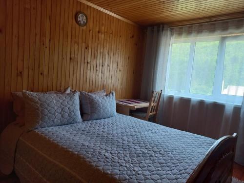 a bedroom with a bed and a window and a table at Yaremche Potik Guest House in Yaremche