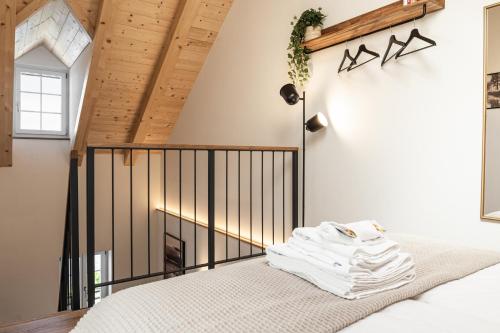 ein Schlafzimmer mit einem Bett und einer Holzdecke in der Unterkunft Studio Lago in Tüscherz-Alfermée
