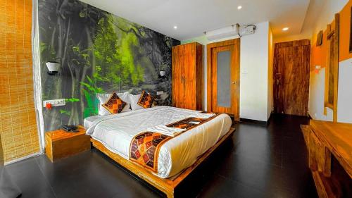 a bedroom with a bed with a painting on the wall at Hillora Coastal Resort Goa in Arpora
