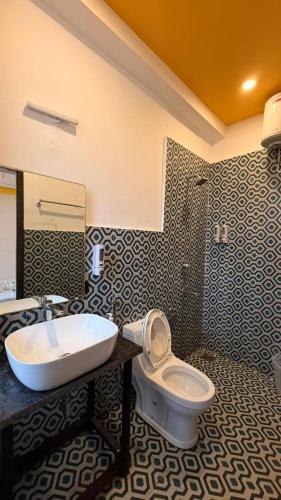a bathroom with a sink and a toilet at Hillora Coastal Resort Goa in Arpora