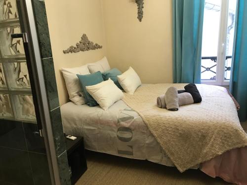 une chambre avec un lit avec des oreillers dessus dans l'établissement Appartement Luxembourg-proche St Germain des prés, à Paris