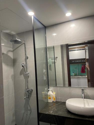 a bathroom with a glass shower and a sink at L'Azur Cửa Lò in Cửa Lô